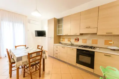 a kitchen with a table and a stove top oven at Trinity Apartments in Castellammare del Golfo