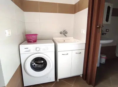 a bathroom with a washing machine and a sink at Trinity Apartments in Castellammare del Golfo