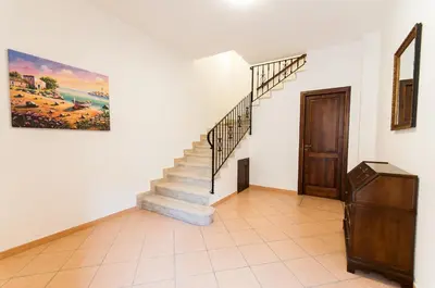 a staircase in a house with a painting on the wall at Trinity Apartments in Castellammare del Golfo
