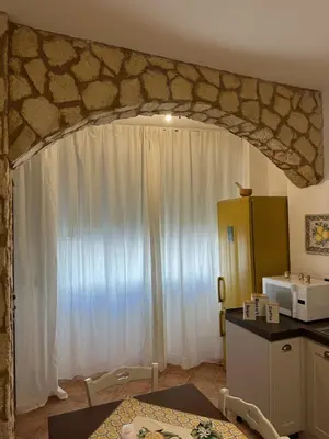a kitchen with a large white curtain and a table at La Kalsa di Somavi in Palermo