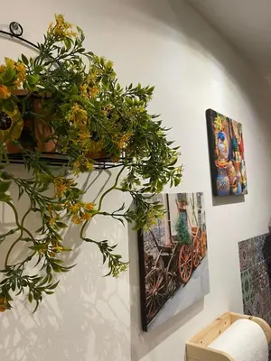 a plant is hanging on a wall with pictures at 'A Sicula in Palermo