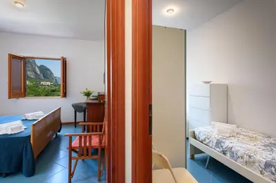 a bedroom with a bed and a desk in a room at Casa ChiaraMarina in Macari