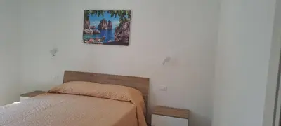 a bedroom with a bed and a picture on the wall at Mamma Rosa Casa Vacanze in Castellammare del Golfo