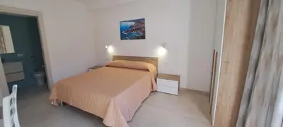 a small bedroom with a bed and a painting on the wall at Mamma Rosa Casa Vacanze in Castellammare del Golfo