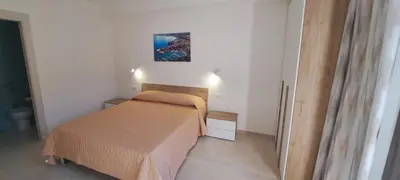 a small bedroom with a bed and a painting on the wall at Mamma Rosa Casa Vacanze in Castellammare del Golfo