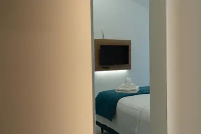 a bedroom with a bed and a tv on a wall at B&B Alba in Terrasini