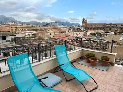two chairs on a balcony with a view of a city at Casa Design con terrazzo in centro storico a Palermo in Palermo