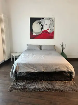 a bedroom with a bed with a painting on the wall at Casa Design con terrazzo in centro storico a Palermo in Palermo