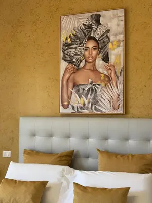a painting of a woman on a wall above a bed at Crispi 120 Rooms New Opening in Palermo
