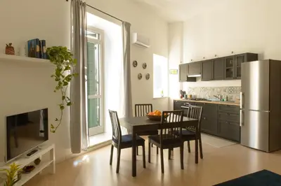 a kitchen with a table and chairs and a refrigerator at La Casa del Mercado in Palermo