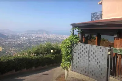 a house with a fence with a view of a city at IL PANORAMA in Altofonte