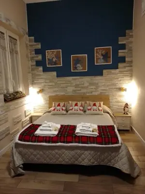 a bedroom with a large bed with a blue wall at Casuzza Bedda e Duci in Mondello