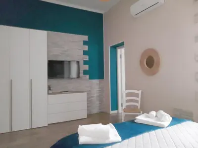 a bedroom with a bed with blue and white walls at Casuzza Bedda e Duci in Mondello