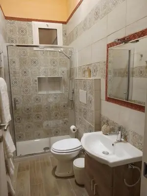 a bathroom with a toilet and a shower and a sink at Casuzza Bedda e Duci in Mondello