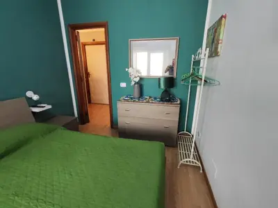 a bedroom with a green bed and a mirror at Medea rooms palermo centro in Palermo