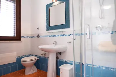 a bathroom with a sink and a toilet and a mirror at Casa Orchidea Bianca in San Vito lo Capo