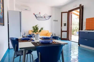 a kitchen and dining room with a table and chairs at Casa Orchidea Bianca in San Vito lo Capo