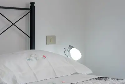 a bed with a white pillow and a mirror at Bedda Luna Villa in San Vito lo Capo