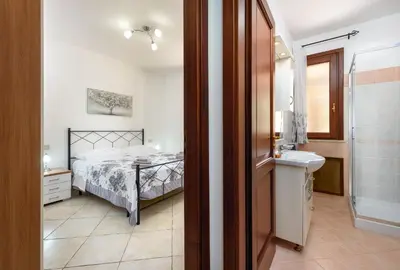 a bedroom with a bed and a bathroom with a sink at Bedda Luna Villa in San Vito lo Capo