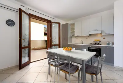 a kitchen with a white table with chairs and a counter at Bedda Luna Villa in San Vito lo Capo