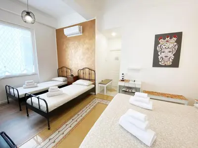 a living room with two beds and a table at Casa Granatelli in Palermo
