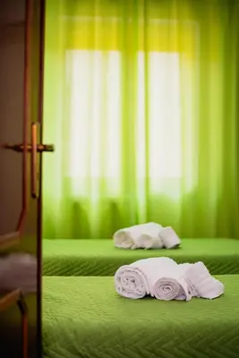 two beds in a green room with towels on them at VILLA HEMINGWAY - LA Casa di Alessia e La Casa di Leonardo in Ficarazzi