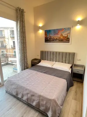 a bedroom with a bed with a painting on the wall at Bella Vita Palermo in Palermo