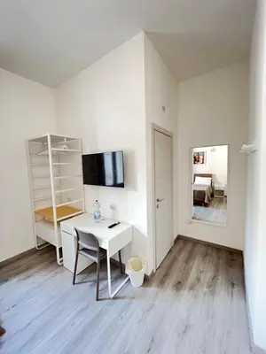 a white room with a desk and a tv at Bella Vita Palermo in Palermo