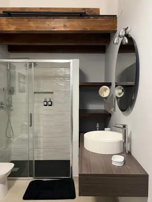 a bathroom with a glass shower and a sink at GDM central apartment Palermo in Palermo