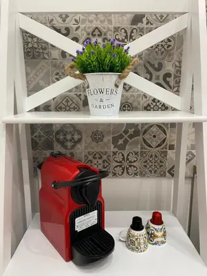 a red toaster and a flower pot on a shelf at La Piccola Formica Home in Palermo