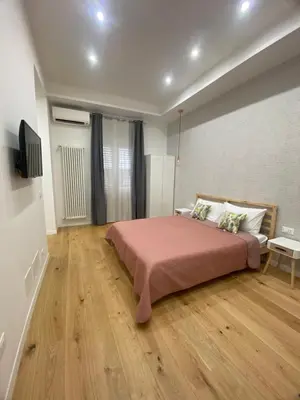 a bedroom with a large bed and a wooden floor at La Piccola Formica Home in Palermo