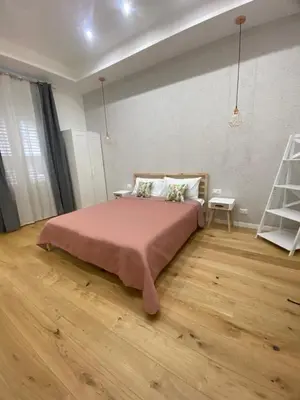 a bedroom with a large bed with a pink blanket at La Piccola Formica Home in Palermo