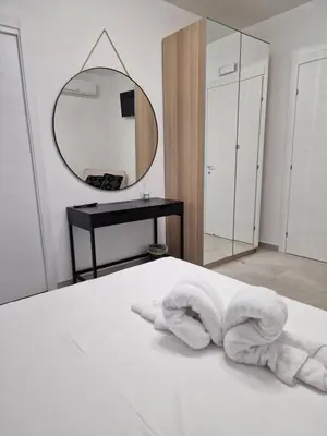 a bedroom with a bed with a mirror and towels at Villa Fragi in Cinisi