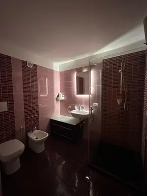 a bathroom with a toilet and a sink and a shower at Prince Suite Palermo in Palermo