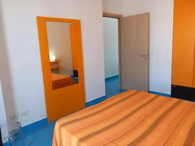 a bedroom with a bed and a mirror at Casa Orchidea Nera in San Vito lo Capo