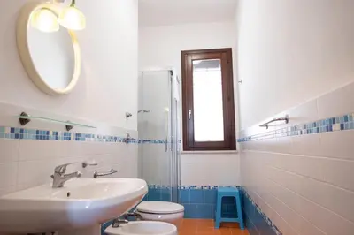 a bathroom with a sink and a toilet and a mirror at Casa Orchidea Nera in San Vito lo Capo