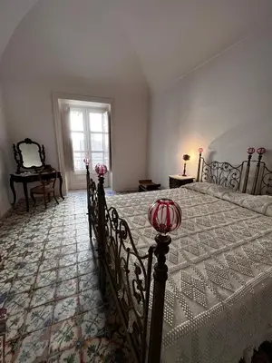 a bedroom with a bed with a white bedspread at Palazzo Triolo - Dimora di Charme in Corleone