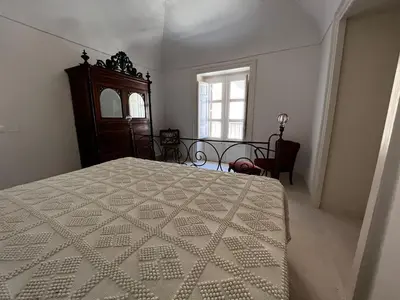 a bedroom with a bed and a dresser and a window at Palazzo Triolo - Dimora di Charme in Corleone