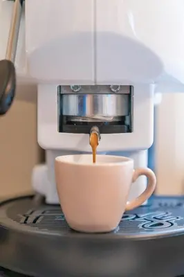 a coffee maker pouring coffee into a coffee cup at B&B Handy Palermo in Palermo