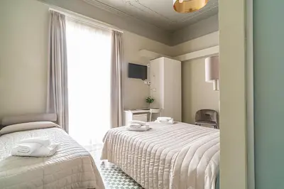 a bedroom with two beds and a window at B&B Handy Palermo in Palermo