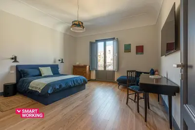 a bedroom with a bed and a desk and a desk at Porta di Castro Design Apartment with Terrace by Wonderful Italy in Palermo
