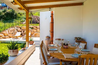a wooden table and chairs on a patio at Villa Bellacosa con Piscina Privata vista mare in Castellammare del Golfo