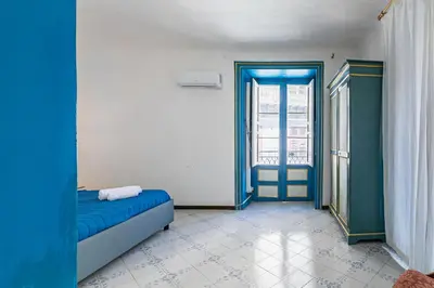 a room with a blue bed and a window at Piazza Pretoria & Quattro Canti Roomy Flats with Balconies in Palermo