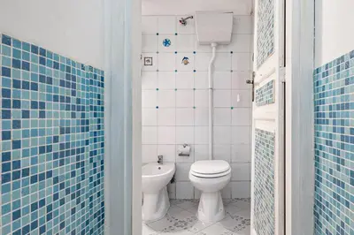 a bathroom with a white toilet and a sink at Piazza Pretoria & Quattro Canti Roomy Flats with Balconies in Palermo