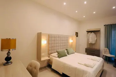 a bedroom with a bed and a table and a chair at Guest House Colonna in Palermo