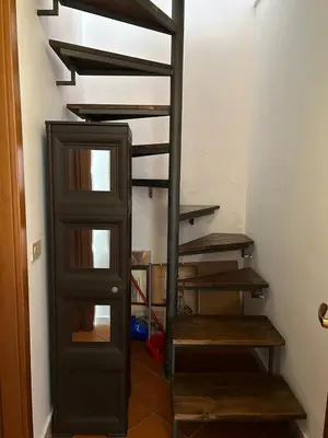 a spiral staircase in a room with wooden steps at Vucciria's house centro storico in Palermo