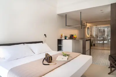 a bedroom with a white bed with a purse on it at Eligius Luxury Apartments in Palermo