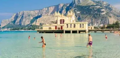 a group of people in the water on a beach at Casa Milù in Palermo