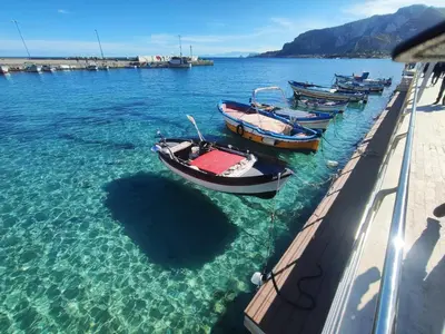 a group of boats in the water near a dock at Casa Milù in Palermo