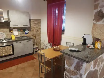 a kitchen with a counter and a table and a counter top at Casa Milù in Palermo